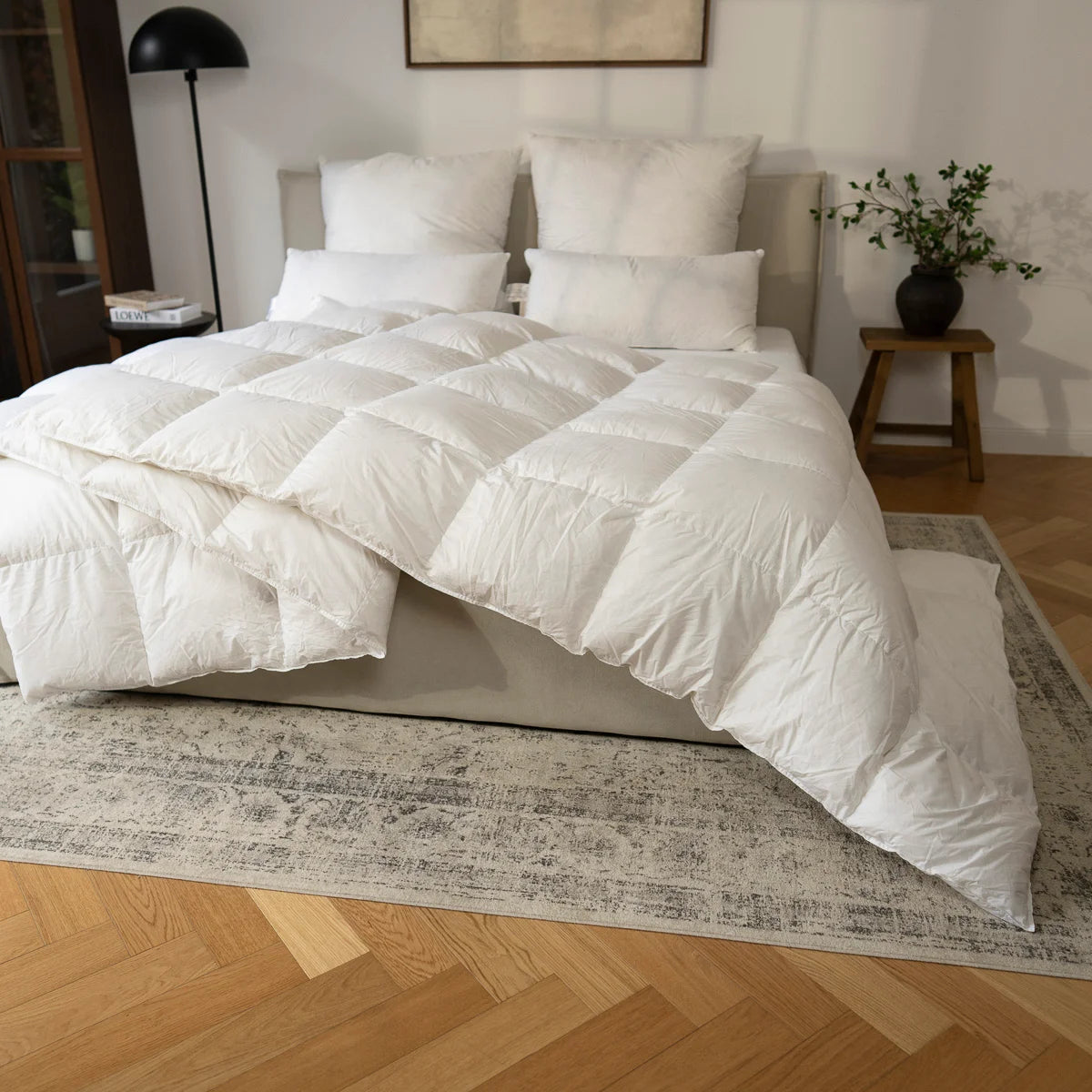 Pure Daunendecke und Kissen Set aus 100 % Gänsedaunen auf einem stilvoll arrangierten Bett, ideal für kuschelige Nächt